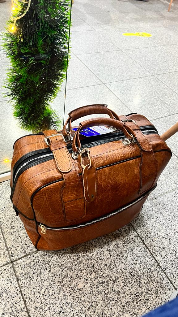 Brown leather travel bag on airport floor